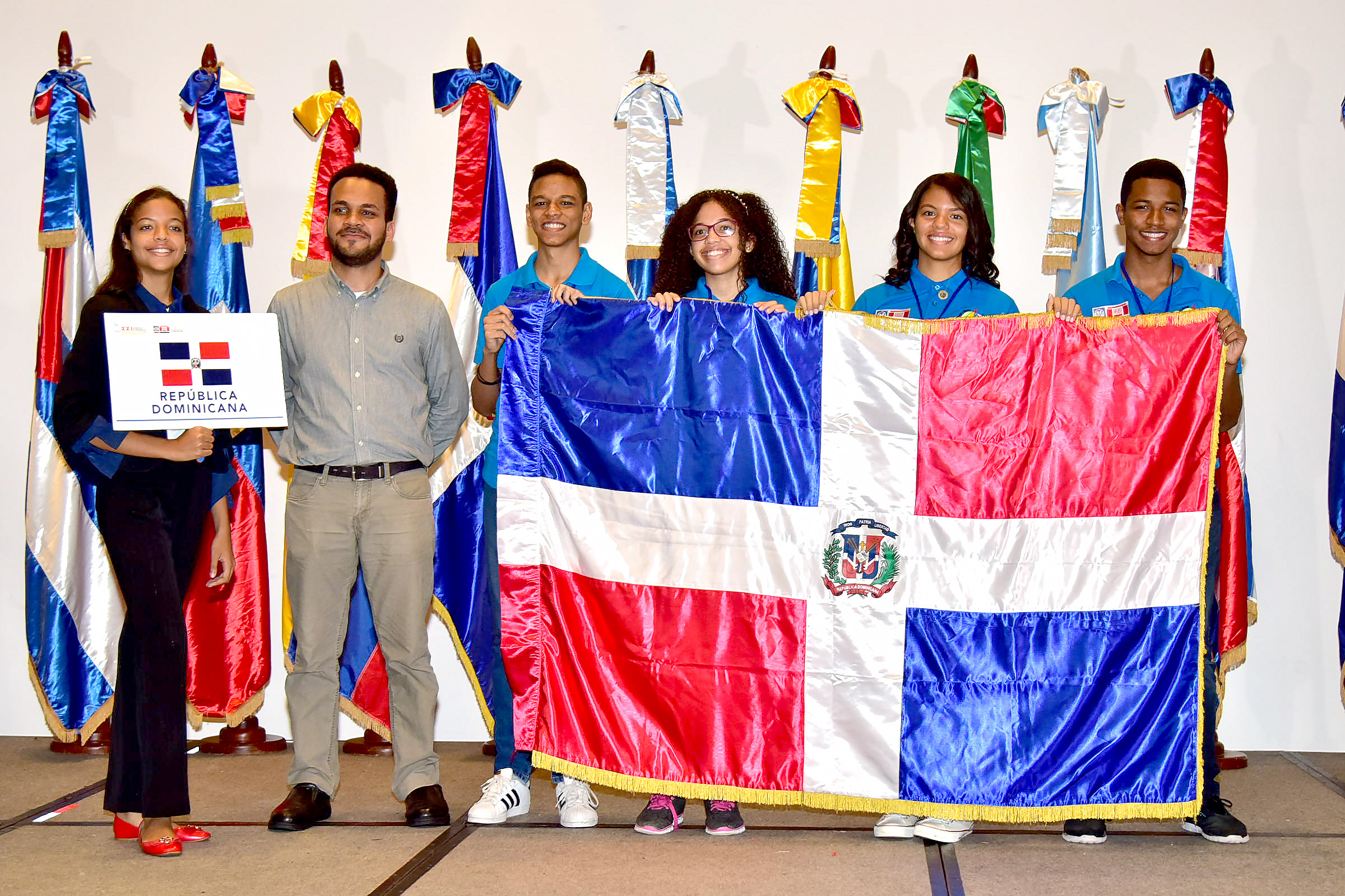  imagen Estudiantes de la delegación nacional sostienen la bandera dominicana. 