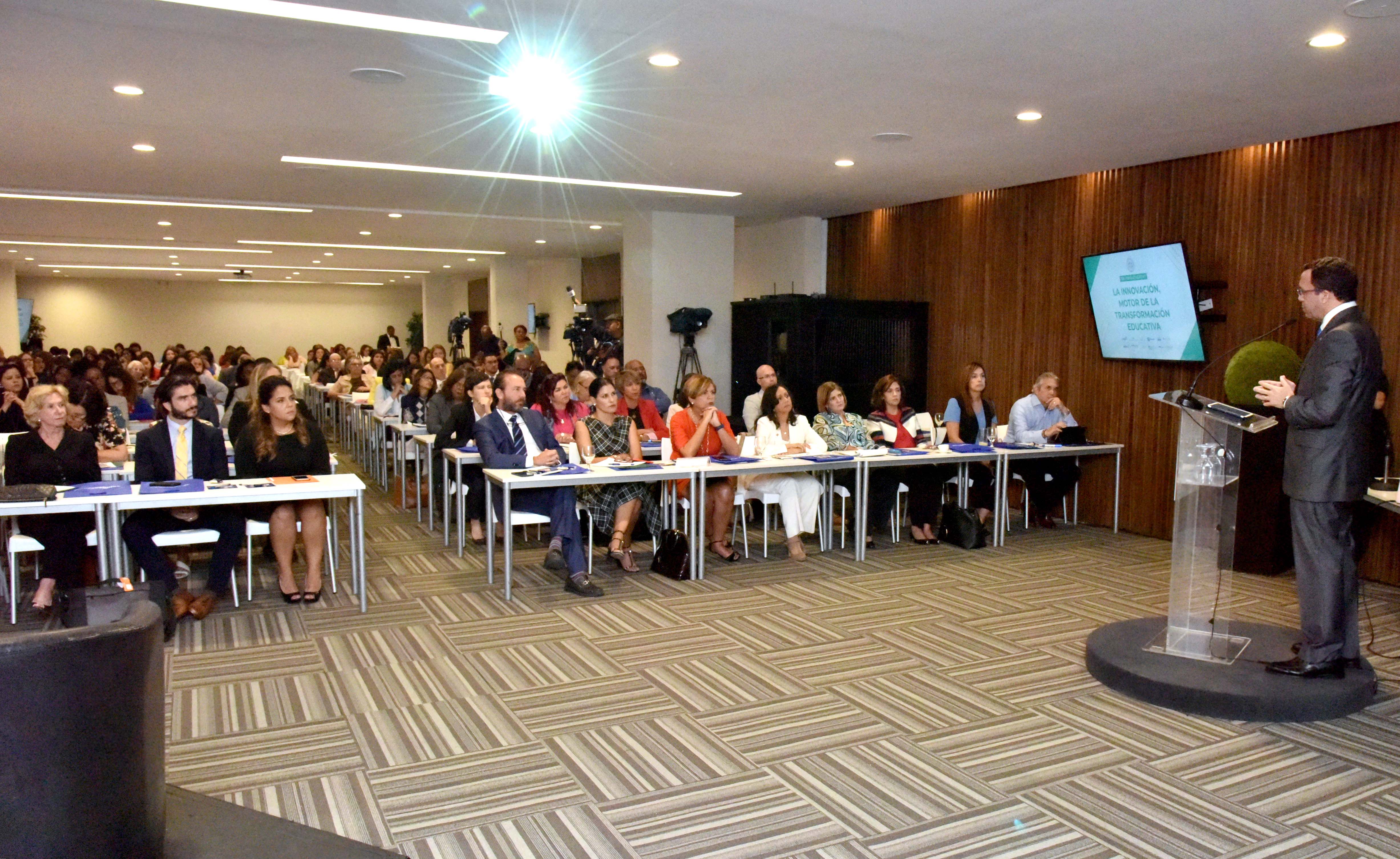  imagen  Ministro Andres Navarro de pie desde podium se dirige a cientos de participantes en conferencia sobre educacion  
