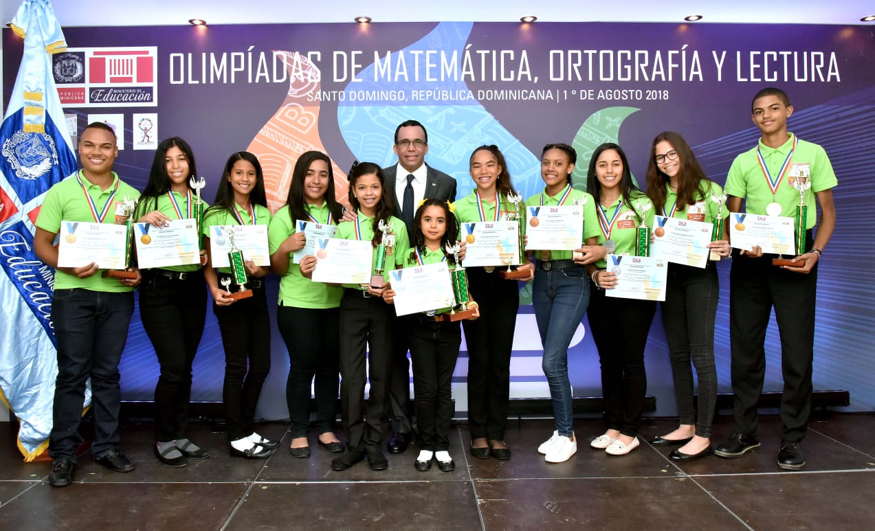  imagen Ministro Andrés Navarro de pie junto a estudiantes galardonados de las olimpíadas de Matemática, Ortografía y Lectura  
