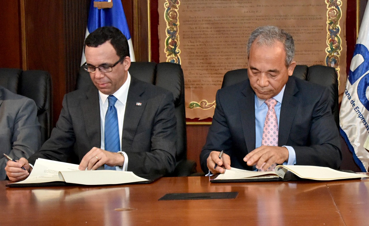  imagen Ministro Andres Navarro y Ruben Bichara sentados firmando acuerdo de cogestion  