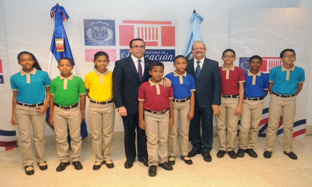  imagen Ministro Andrés Navarro junto al director René Jáquez y grupo de niños que modelan el nuevo uniforme escolar. 