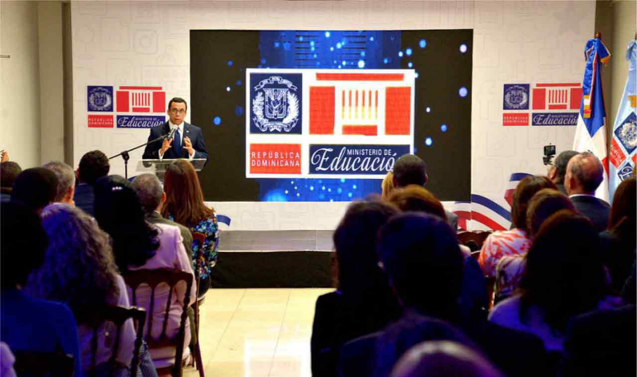  imagen Ministro Andrés Navarro durante su discurso; a su espalda, en pantalla grande, Nueva imagen del Logo Institucional. 