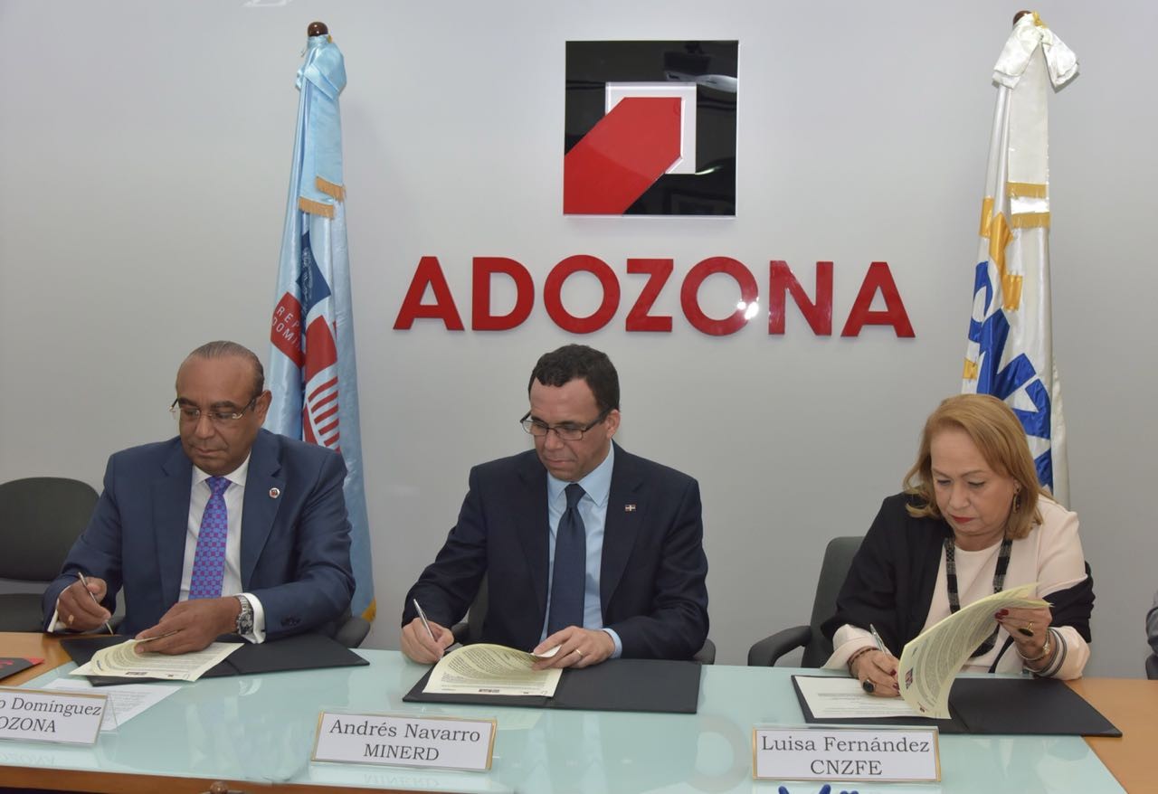  imagen Ministro Andrés Navarro sentado firmando acuerdo junto a directivos de ADOZONA 