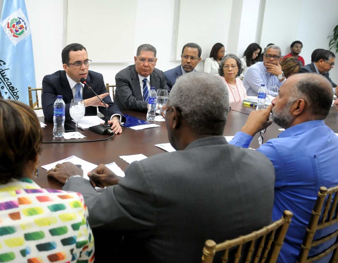  imagen Ministro Andrés Navarro sentado en la mesa junto a integrantes de la ADP, entre otros representantes de distintas áreas. Frente al Ministro, el señor Eduardo Hidalgo. 