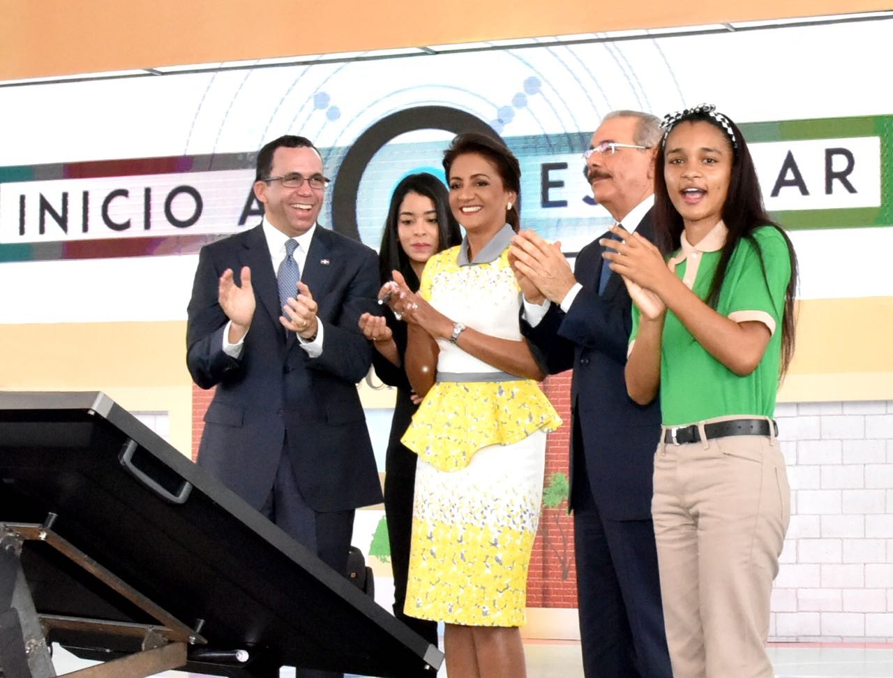  imagen Presidente Danilo Medina,  Primera Dama Candida Montilla de Medina, Ministro Andrés Navarro y estudiante de secuandaria de pies aplaudiendo con alegria el inicio del Año Escolar 2018-2019 