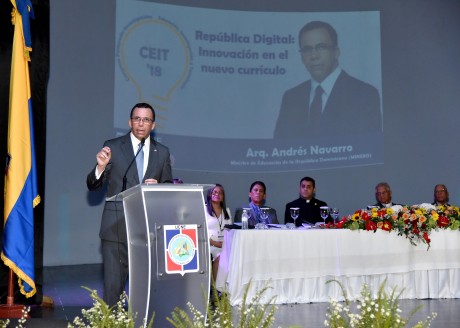  imagen Ministro AndrÃ©s Navarro de pie en podium exponiendo discurso al lado de mesa principal en posgrado de la Universidad CatÃ³lica Nordestana 
