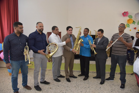  imagen Representantes de la banda musical de la Escuela Miguel Ángel Jiménez con algunos de los instrumentos entregados. 