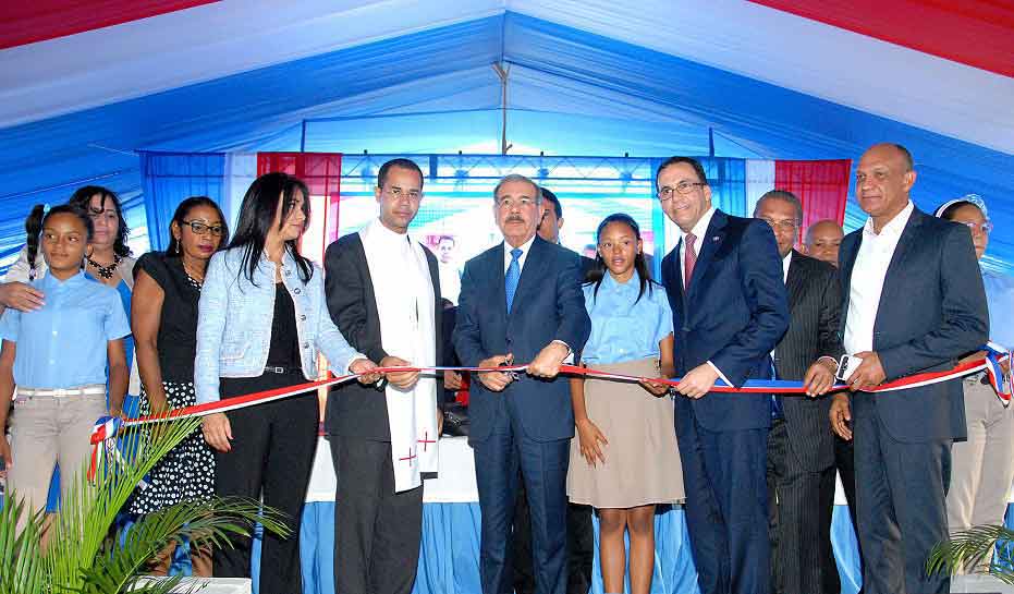  imagen Presidente Danilo Medina corta cinta en acto de inauguraci&oacute;n; a su izquierda Ministro Andr&eacute;s Navarro, entre otras personalidades. 
