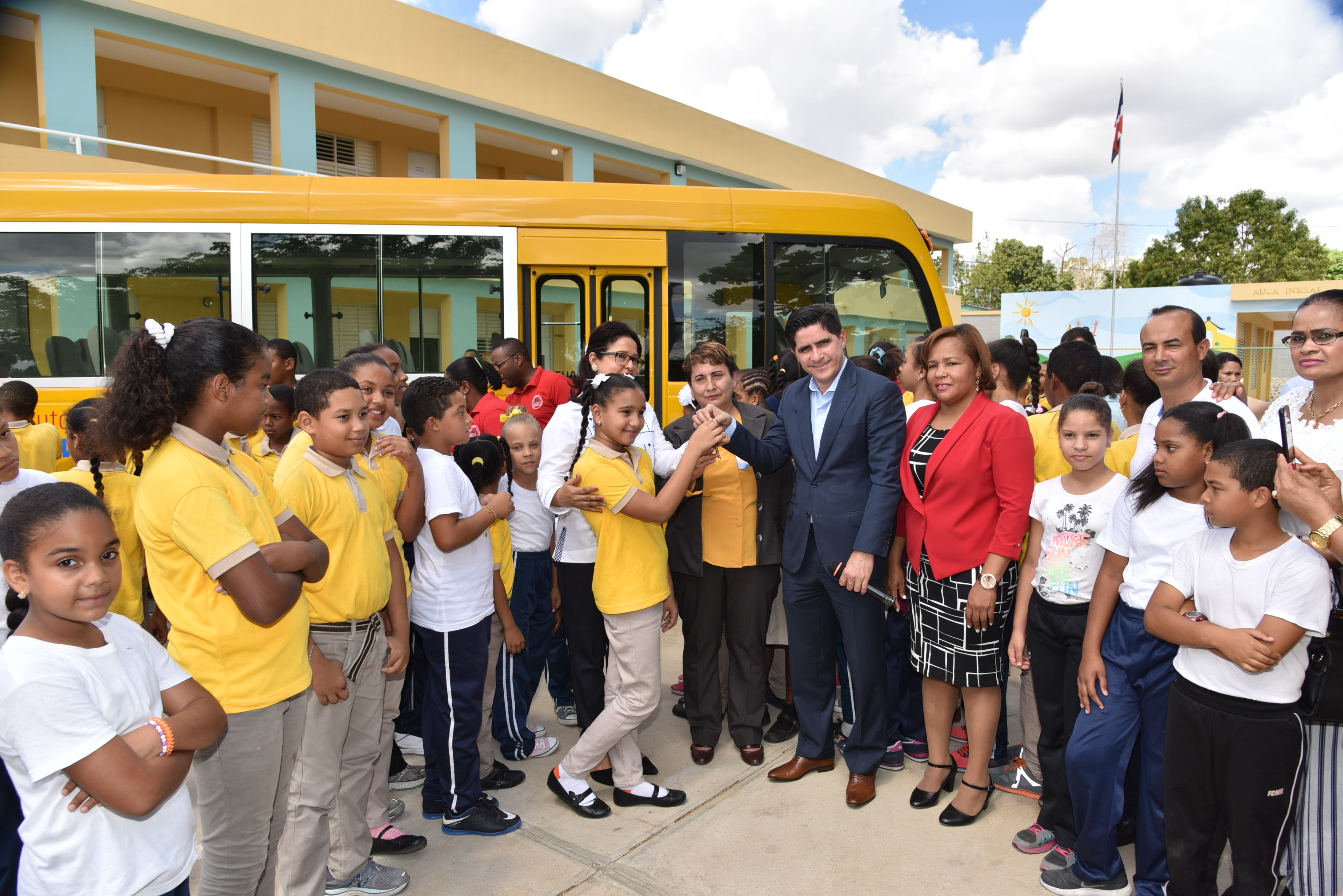  imagen Director Administrativo MINERD, Jorge Luis Moronta de pie entregando llave de nuevo autob&uacute;s escolar a representabtes de la comunidad educativa de Partido Dajab&oacute;n&nbsp; 