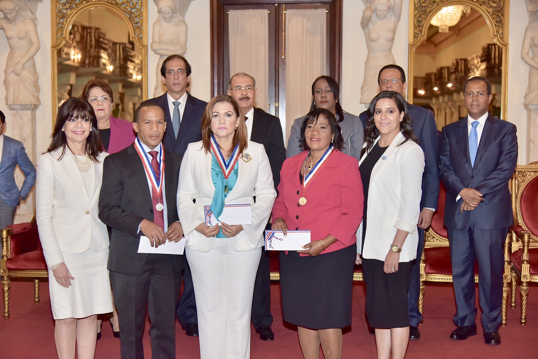  imagen De derecha a izquierda sentados, ministros Alejandrina Germ&aacute;n, Gustavo Montalvo y Presidente Danilo Medina. De pie a la derecha Ministro Antonio Pe&ntilde;a Mirabal entrega reconocimiento a&nbsp;Mar&iacute;a Marinick. 