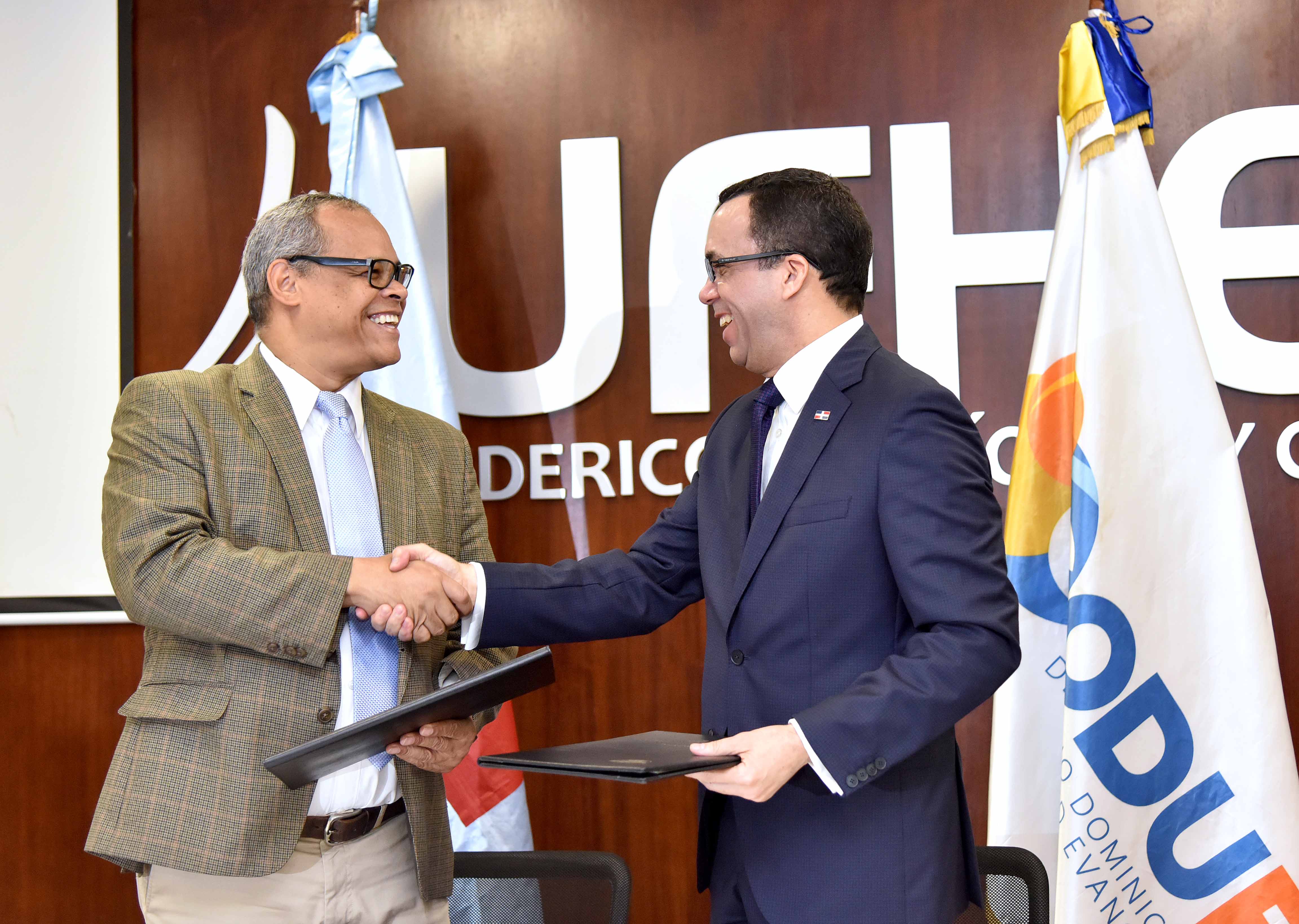  imagen Ministro And&eacute;s Navarro de pie junto a presidente del CODUE&nbsp; estrechandose las manos luego de firma de convenio&nbsp; 