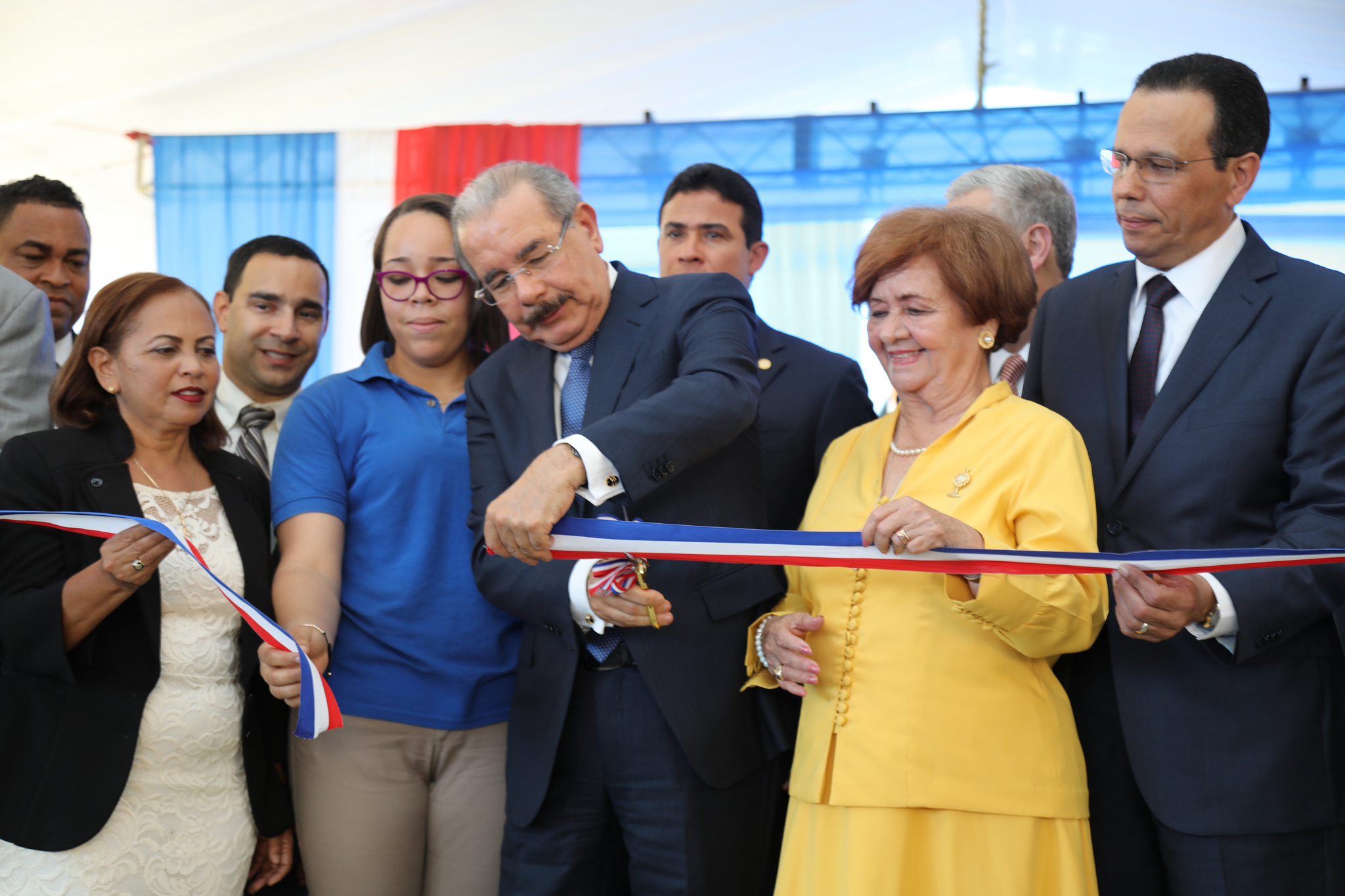  imagen Presidente Danilo Medina de pie cortando cinta junto a ministro Antonio Pe&ntilde;a Mirabal y dem&aacute;s autoridades educativas 