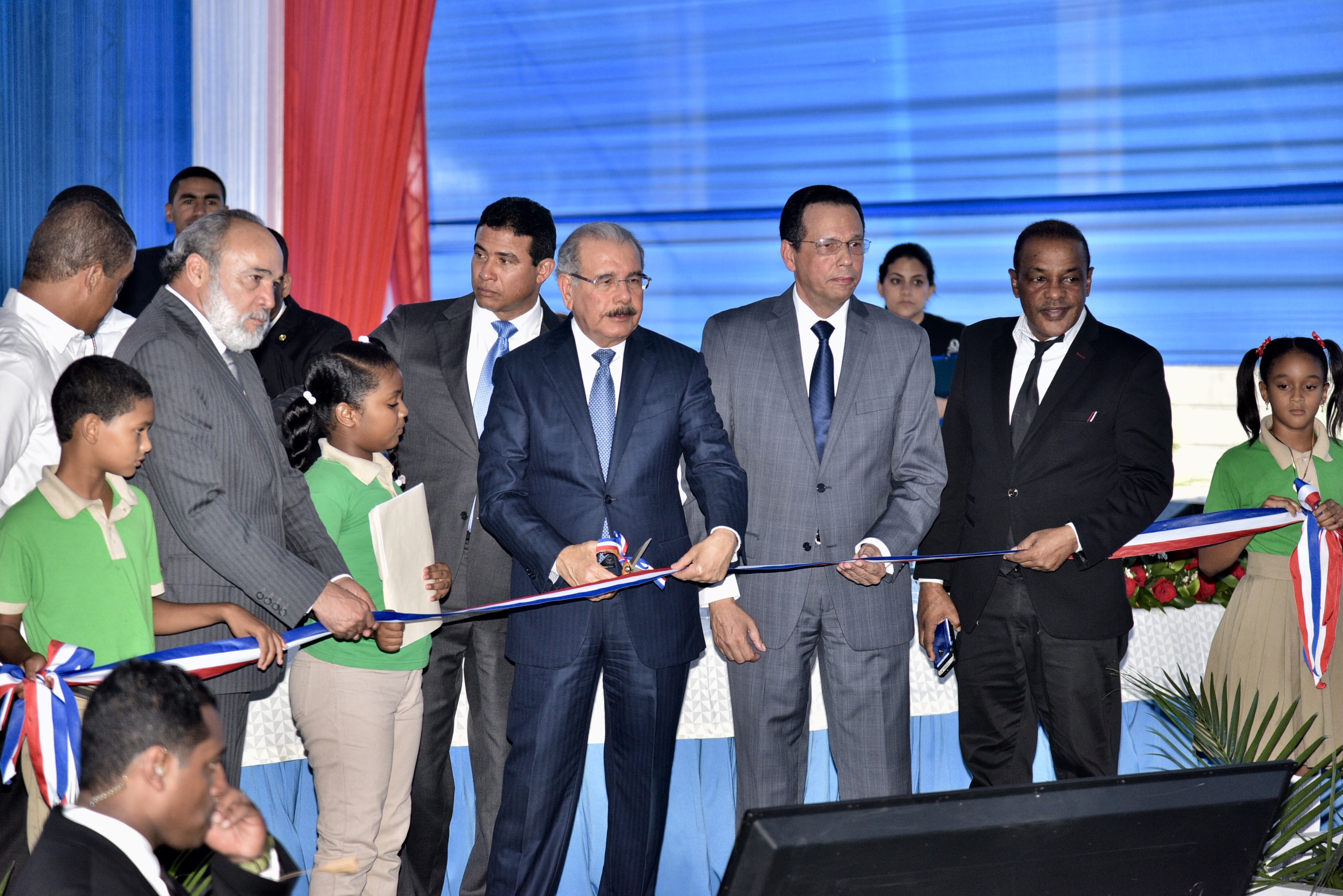  imagen Presidente Danilo Medina y ministro Antonio Pe&ntilde;a Mirabal de pie junto a autoridades educativas cortando cinta de acto inaugural&nbsp; 