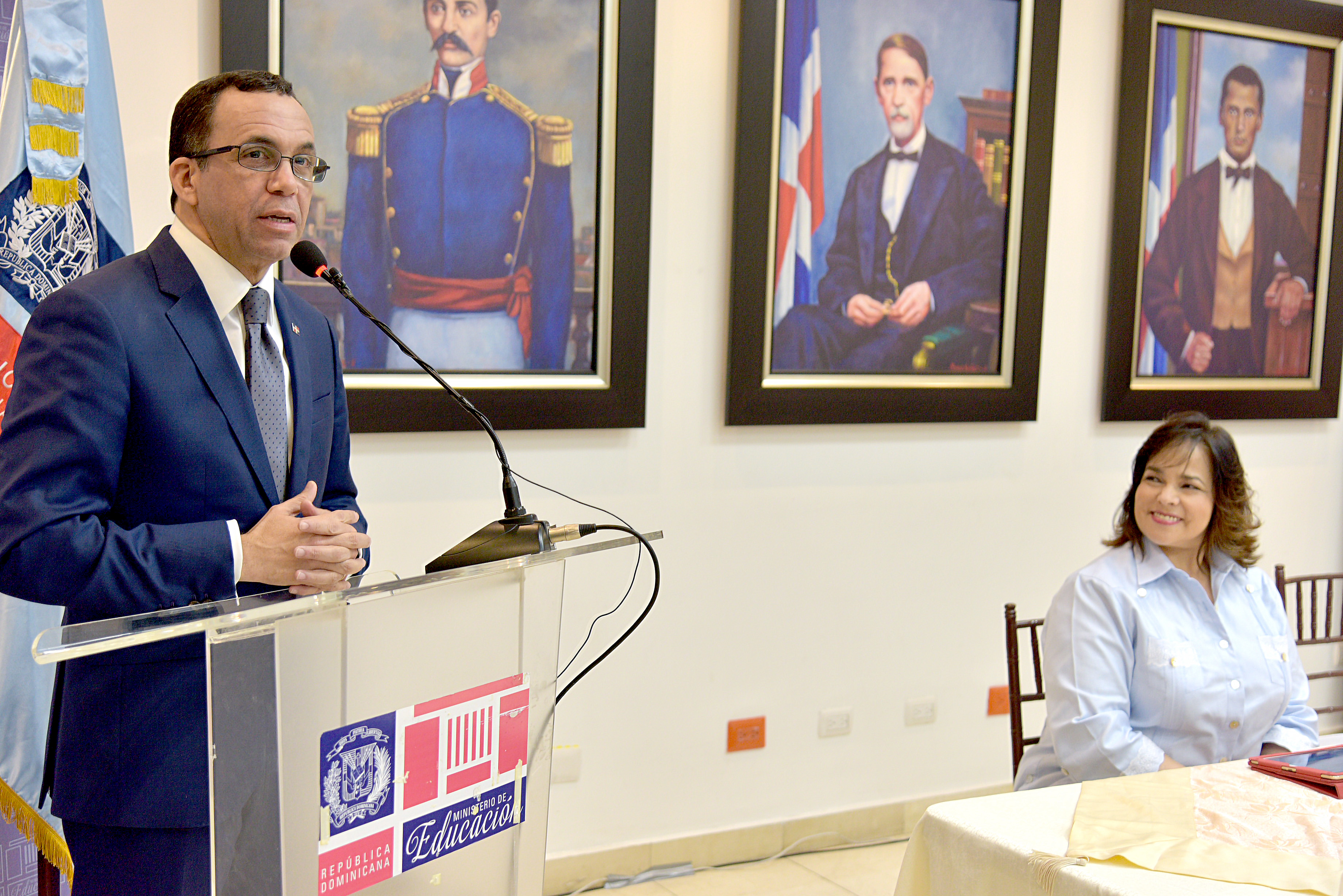  imagen Ministro Andr&eacute;s Navarro de pie desde podium al lado de Directora General de Compras y Contrataciones quien est&aacute; sentada en mesa principal dejando aperturado nuevo taller institucional&nbsp; 