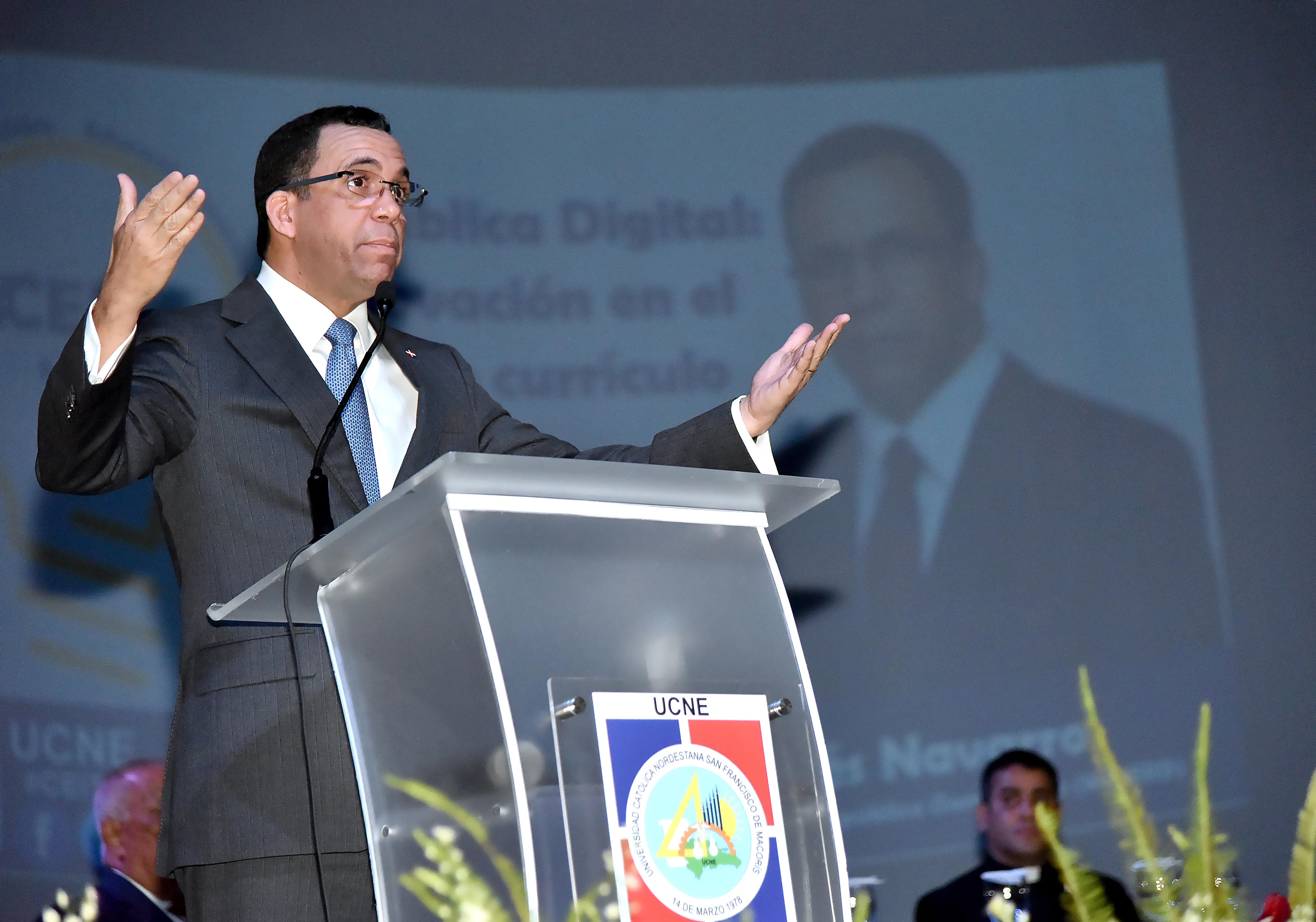  imagen Ministro Andr&eacute;s Navarro de pie en podium exponiendo discurso al lado de mesa principal en posgrado de la Universidad Cat&oacute;lica Nordestana 