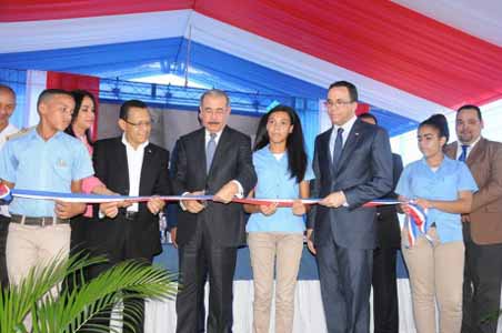  imagen Presidente Danilo Medina mientras corta cinta en acto de inauguraci&oacute;n, a su izquierda una de las estudiantes presente seguido, el Ministro Andr&eacute;s Navarro. Entre otras personalidades. 