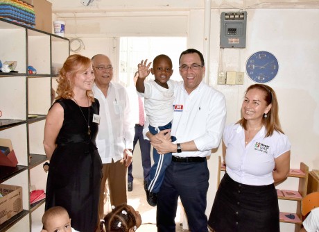  imagen Ministro Andr&eacute;s Navarro soriendo mientras carga a ni&ntilde;o rodeado por miembros del Patronato Ben&eacute;fico Oriental. 